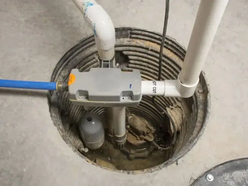 Sump pump, float and discharge pipe sitting in a pit cut into a basement floor